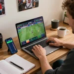 O8 sports betting setup with user tracking game statistics on laptop and smartphone in a cozy environment.