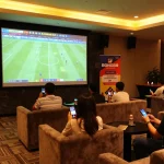 Engaged bettors enjoying a match while placing bets at BONG88's vibrant sports betting lounge.